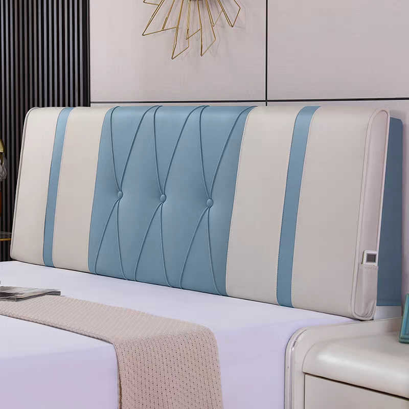A bed with a large blue and white headboard featuring button-tufted design and light blue vertical stripes, positioned against a wall with modern decor and a gold wall sculpture.