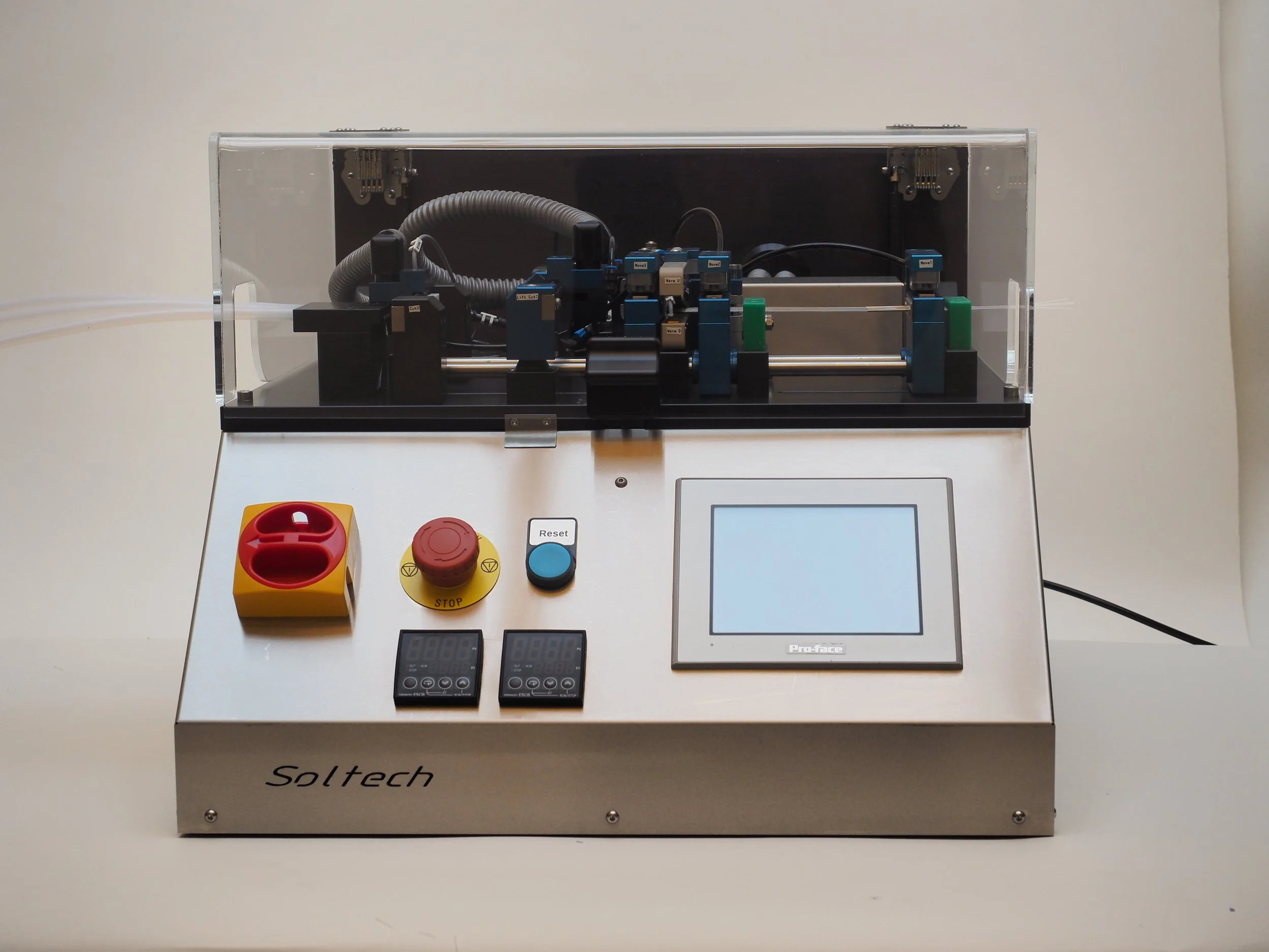 Laboratory automation device with a touchscreen display, emergency stop button, reset button, and control units, with mechanical components inside a clear protective cover.