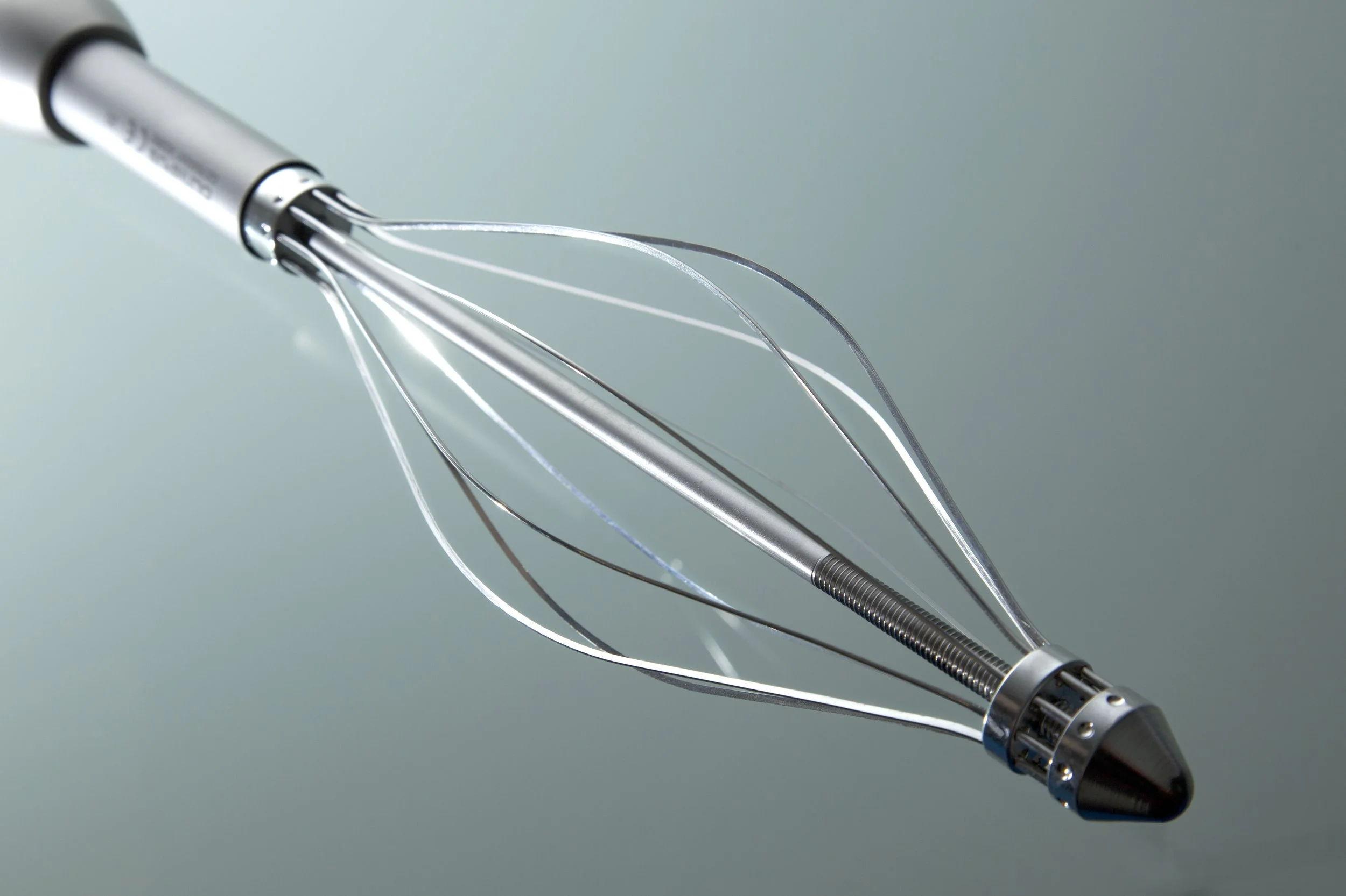 A metallic whisk with a black handle, used medical purposes
