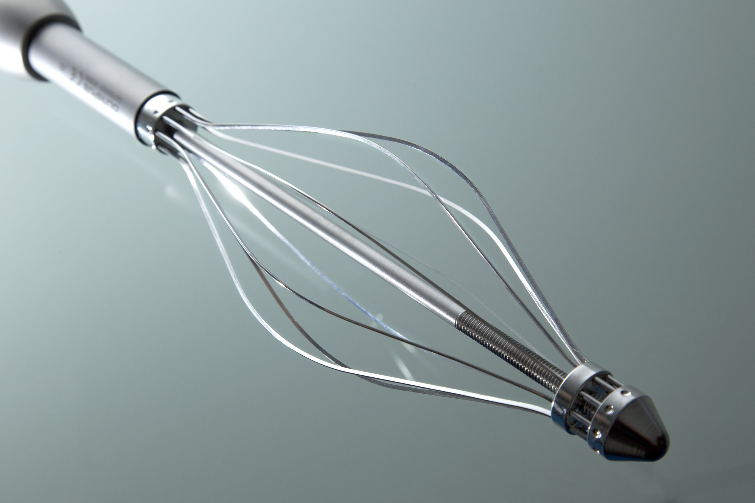 Close-up of a metal medical whisk with multiple razorblade wires