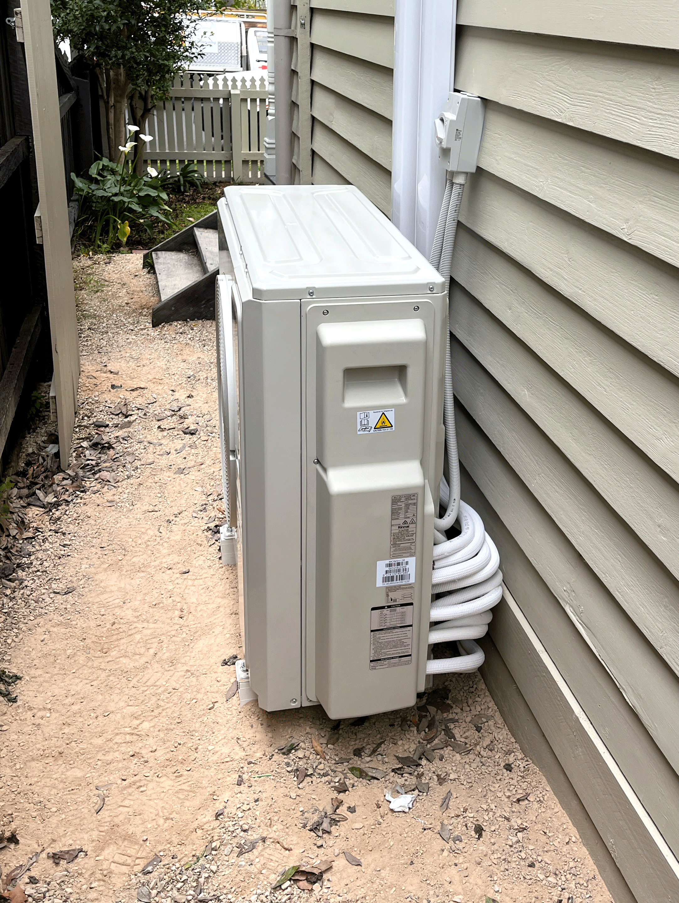 An expertly installed AC unit by JCT Services, on the outside of a residential property, making sure it operates reliably and efficiently so that the home stays cool in Summer and Warm in winter