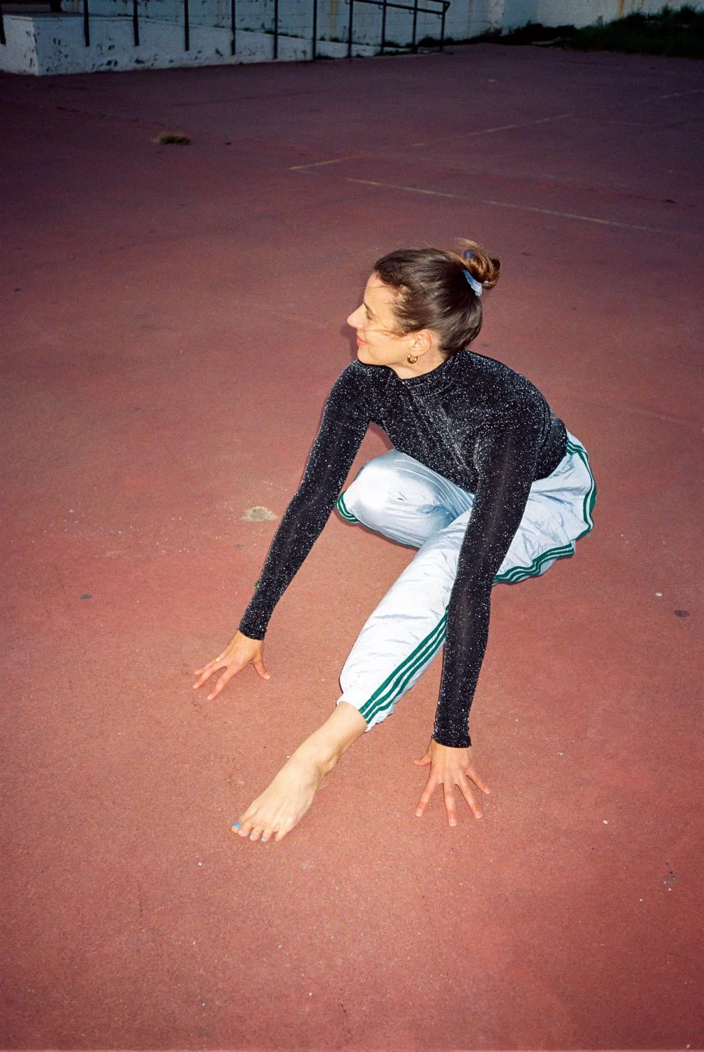 Mensch beim Bewegen auf Basketballplatz in tiefer Hocke.