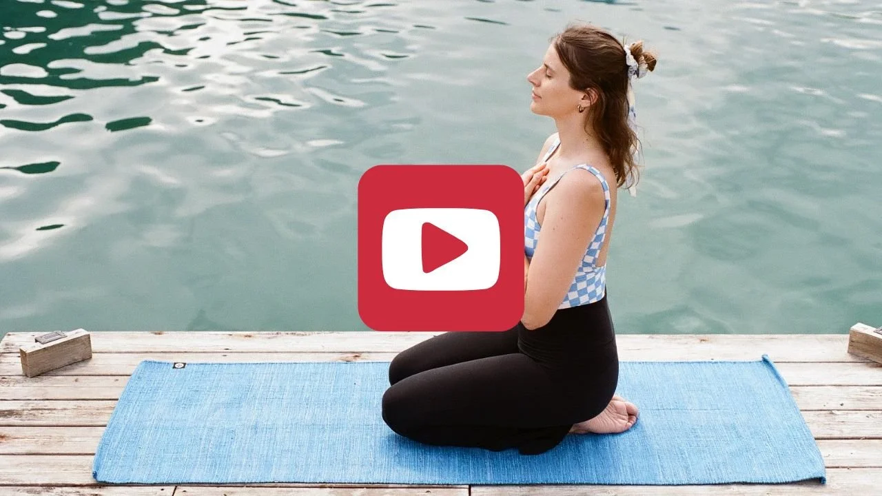 Ein Play-Button vor einer Yoga-Szene am See.