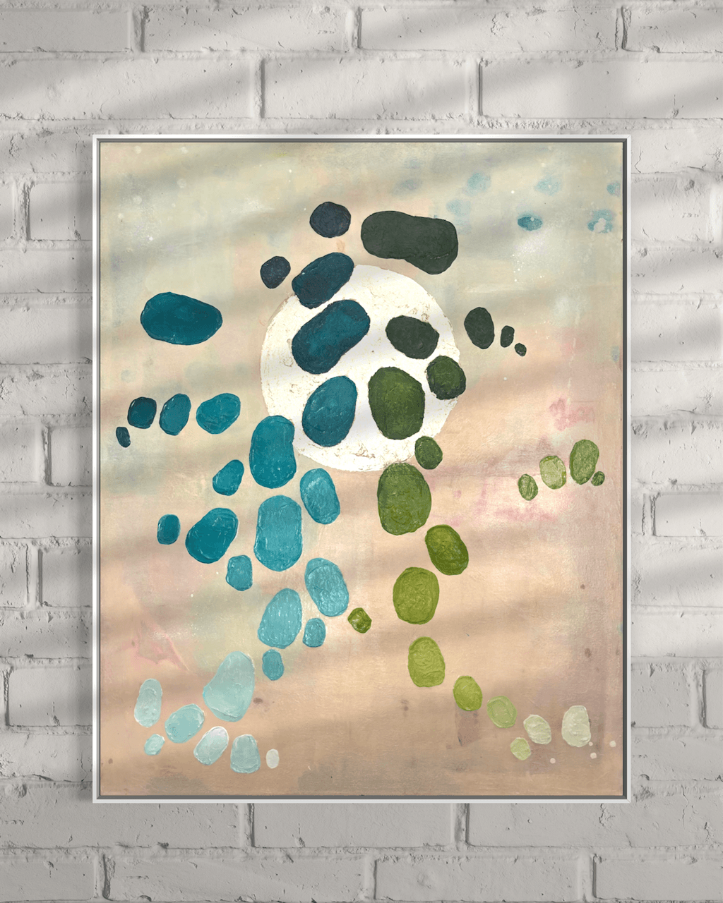 Artwort from the series Dancing Palette by Birgit Trofer mounted on a white brick wall with beautiful sunlight and shadows allowing to experience the different nuances of the aqua, teal and green hues and the shine of the gold leaf on the painting.