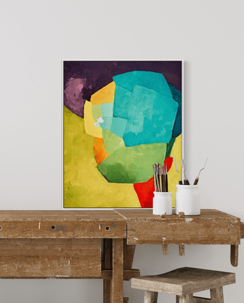 Bold Allure, a color field abstract artwork by Birgit Trofer, on the studio shelf surrounded by brushes and painting utlities, framed in a white floating frame.