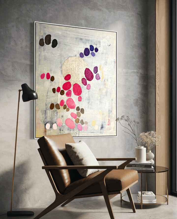 Graceful Dance, an original abstract artwork by Birgit Trofer, in a cozy reading area of a hotel with lots of natural light coming in, letting the pink nuances of the painting, and the gold leaf shine.