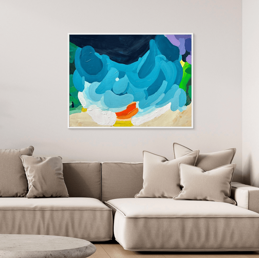 Elegant abstract painting Luminous Tide by Birgit Trofer in a white floating frame, styled above a soft sofa with bright beige pillows in a cozy interior.