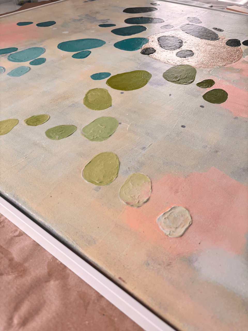 Close-up des abstrakten Kunstwerks Inventing New Ground aus der Serie Dancing Palette von Birgit Trofer, im Studio während des Rahmens. Das natürliche Licht fällt auf das Blattgold und lässt die einzelnen Farbnuancen scheinen.