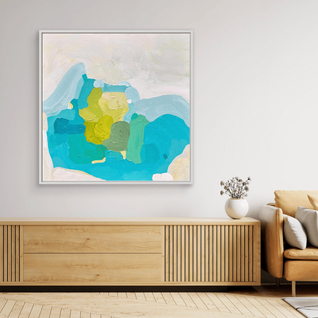 Coastal artwork by Birgit Trofer, turquoise and aqua color fields with contrasting lime green, in white floating frame in neutral living room above a shelf.