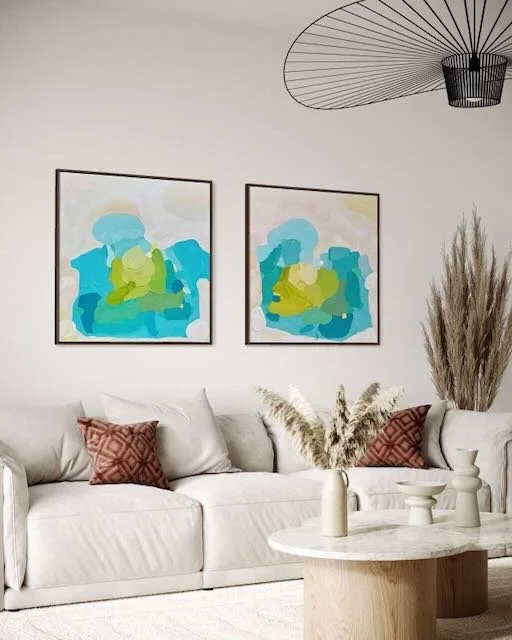 Harmonisches Kunst-Diptychon aus Aquamarine Muse und Shoreline Serenity von Birgit Trofer über einer hellen Couch in einem gemütlichen Wohnzimmer.