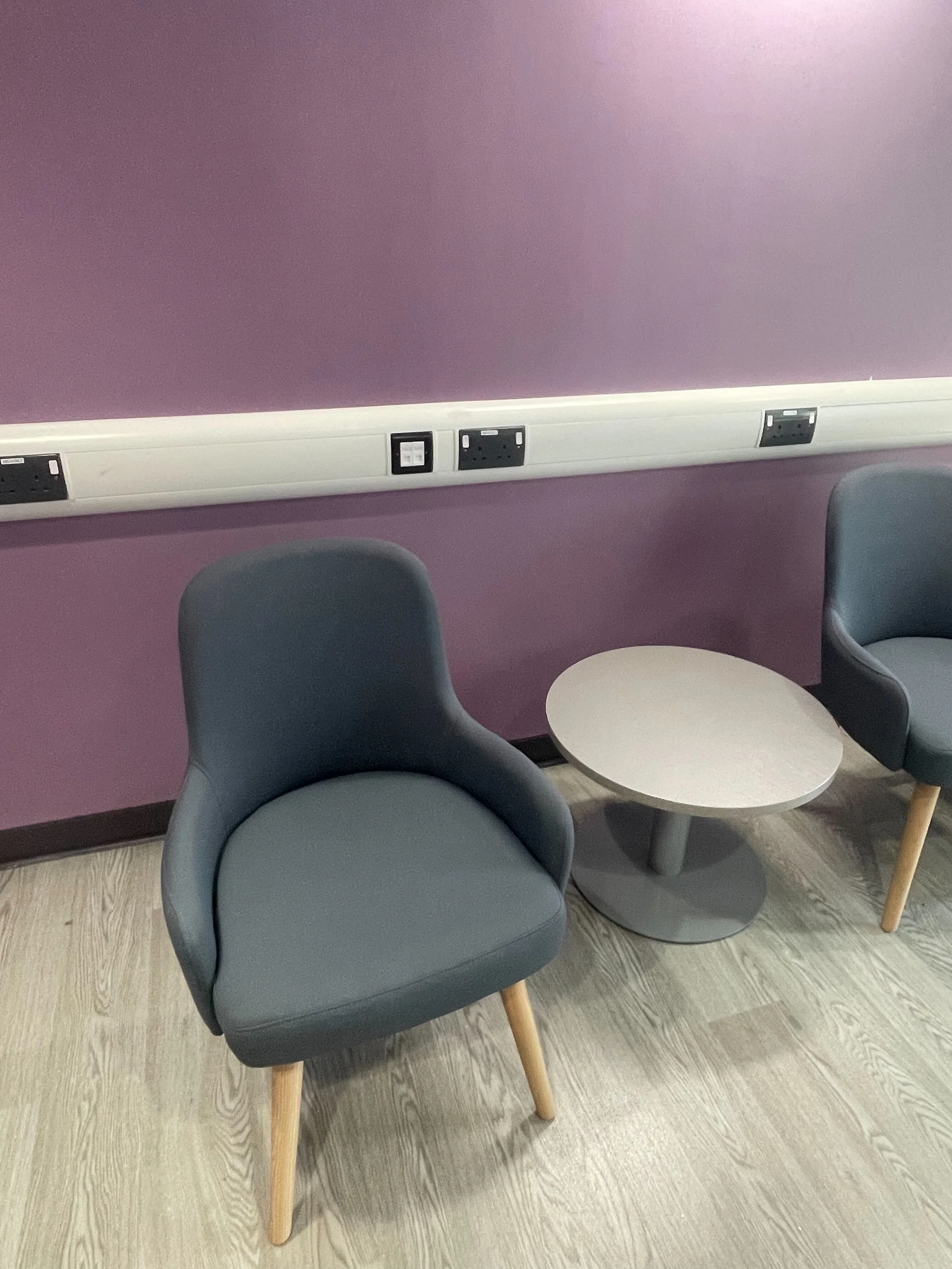  Close up image of the new furnishings - two grey comfy chairs and a small white table.  
