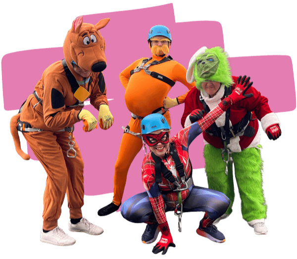Photo of four participants posing together in fancy dress costumes as Scooby-Doo, the Lorax, the Grinch and Spider-Woman, with a decorative pink swoop graphic behind them.