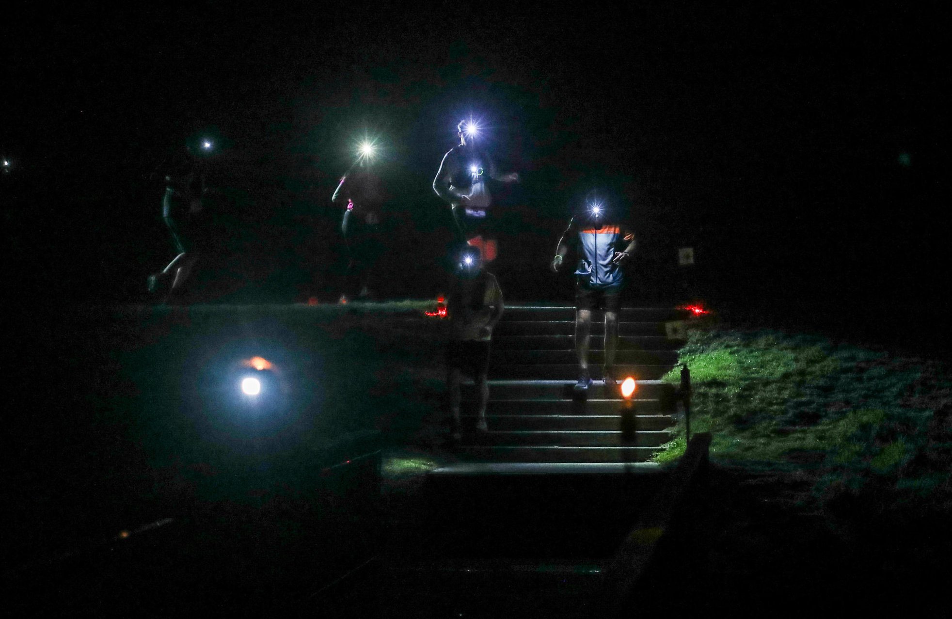 Photo de traileurs de nuit descendant des marches avec leur frontale. Photo prise par Thierry Sourbier