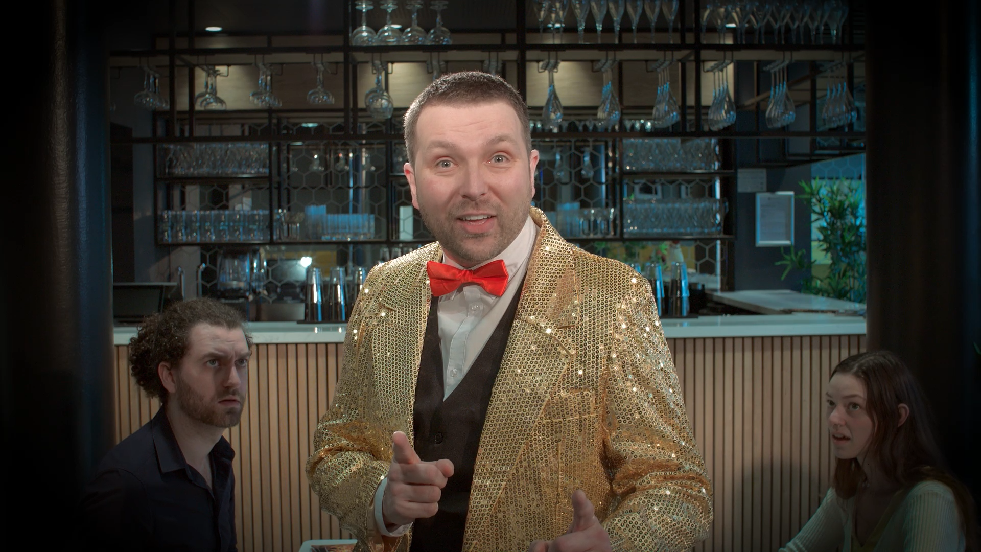 A live band performing on an outdoor stage at the House of Social event, with a female singer in a long gray dress, and four male musicians playing guitar, drums, and keyboard. The stage has a colorful backdrop with vibrant graphics and the event name.