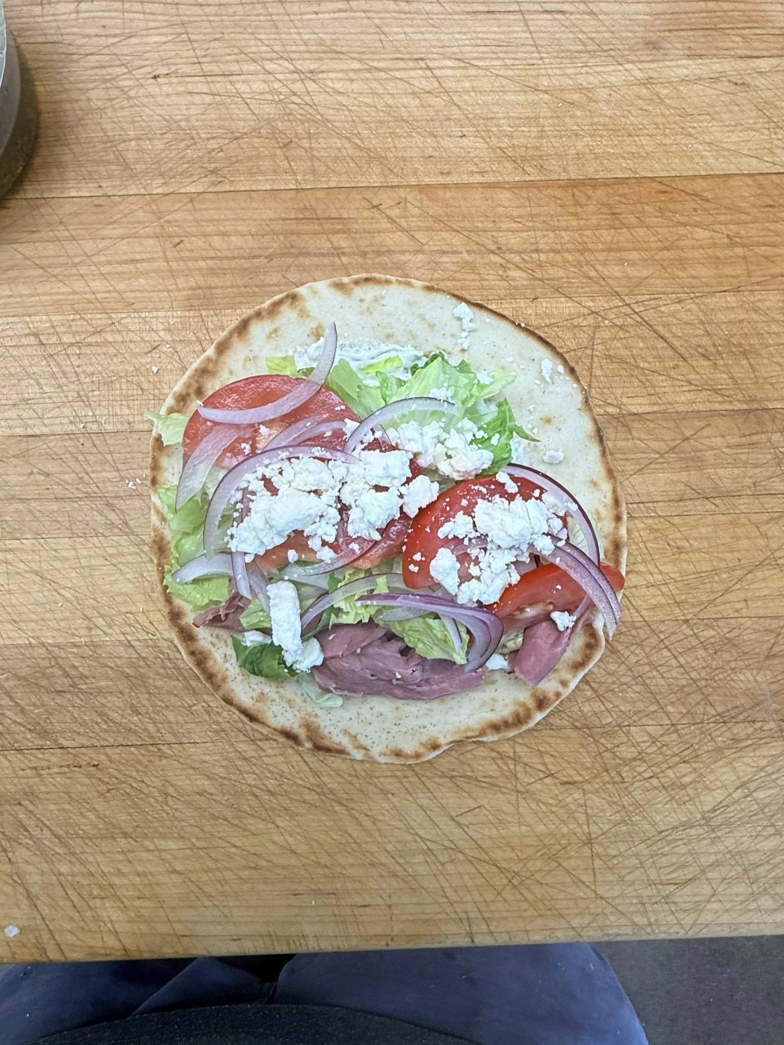Roast beef gyro on butcher's block at butcher shop.