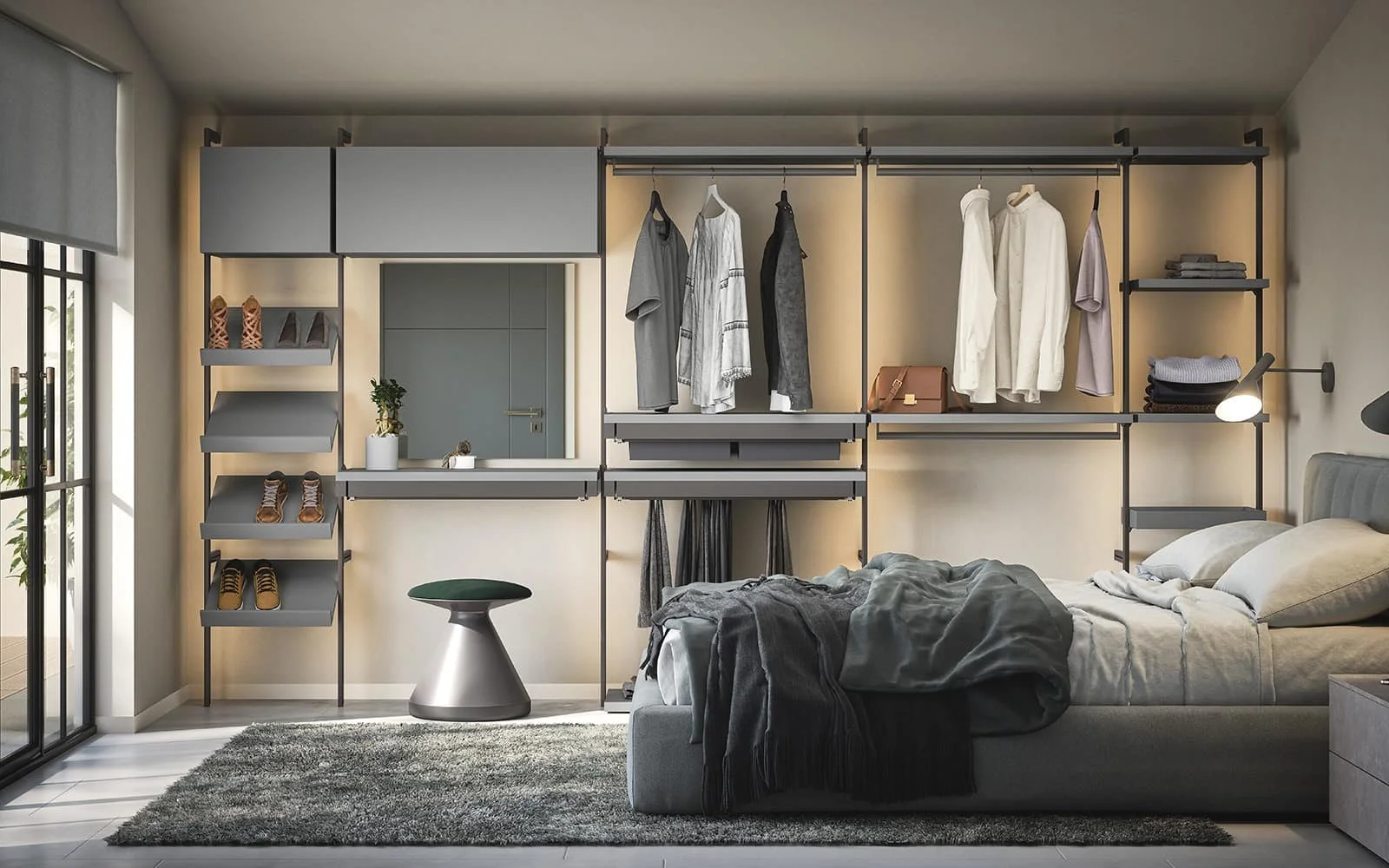A modern bedroom with a bed, a grey rug, and an open closet with hanging clothes, shoes, and shelves. There is a small table, a window with blinds, and a mirror on the wall.