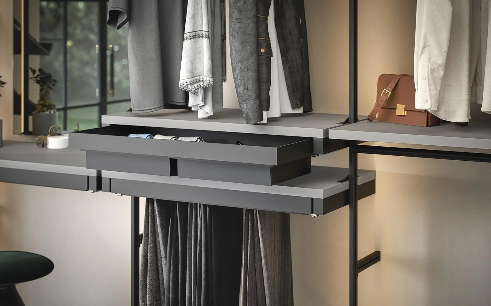 Closet organising system with hanging clothes, open drawer with accessories.