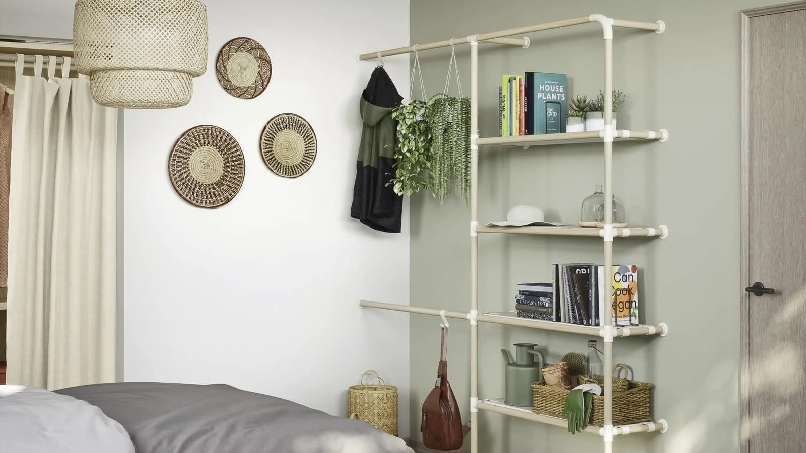 Interior view of a bedroom corner with a bed, a wall with decorative woven baskets, and a modern ladder-style bookshelf with plants, books, and decorative items.