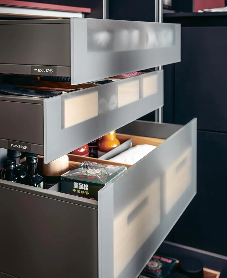 Open kitchen drawer filled with condiments, jars, and packaged foods.