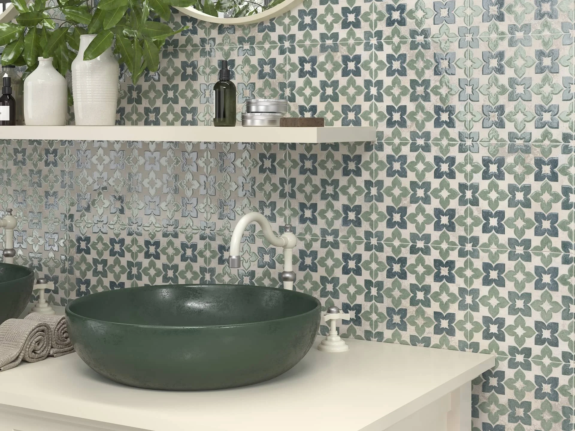 A bathroom with patterned tile backsplash, a large green vessel sink, white countertop, and shelving with decorative bottles and vases.