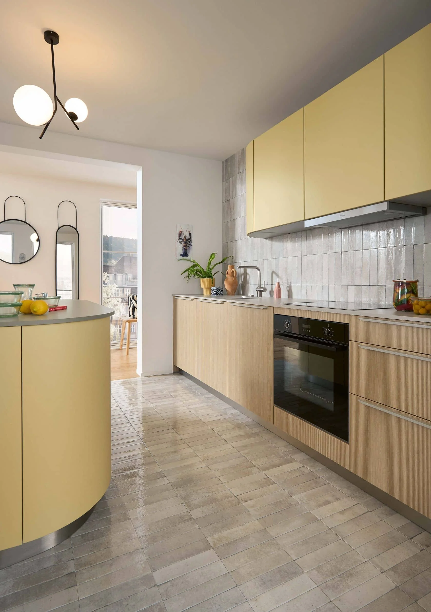 Modern kitchen with yellow upper cabinets, light wood lower cabinets, tile backsplash, black built-in oven, and a curved yellow kitchen island.