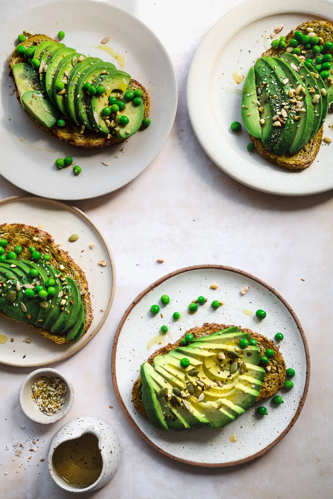 Open-faced avocado sandwich with sliced avocado and green peas on toasted bread
