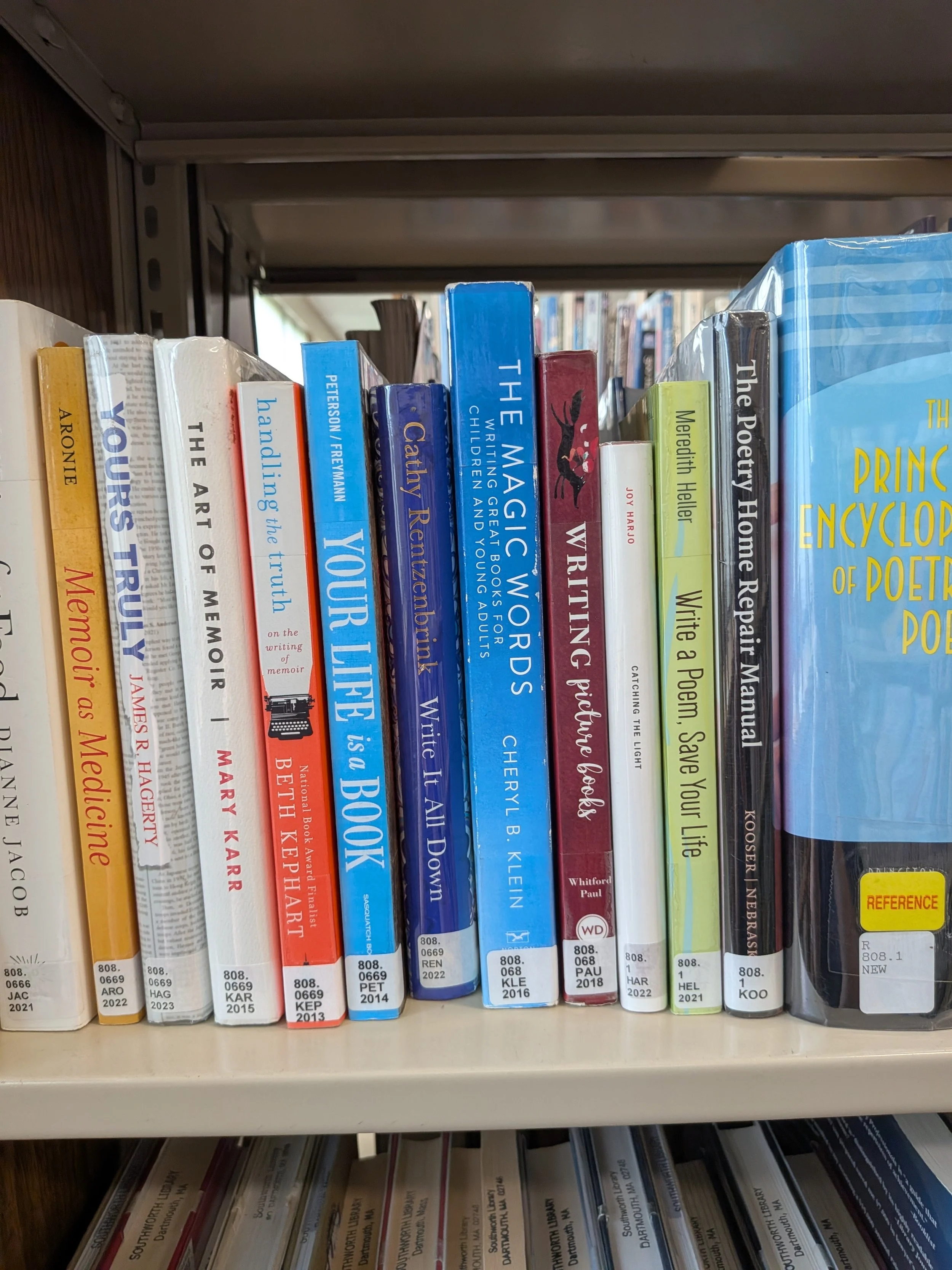 A library bookshelf filled with writing and poetry books arranged upright with visible number labels.