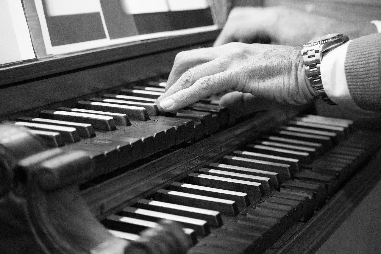 Black-and-white close-up of hands playing the keys of a piano