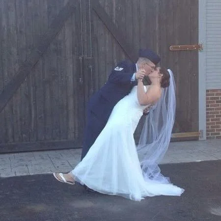 Wedding photo of the author, Sarah Kiepper kissing and holding hands with her husband.