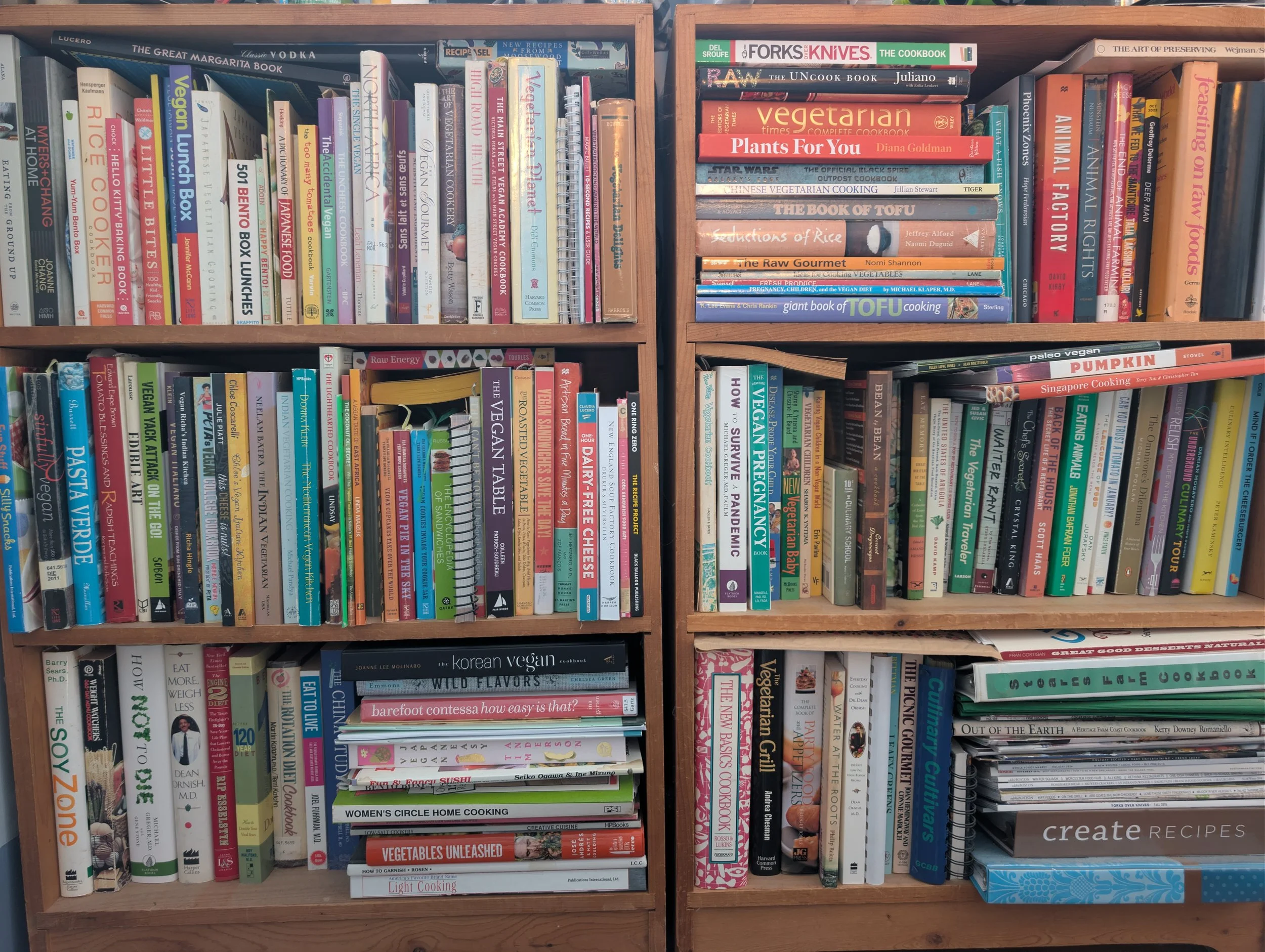 Large wooden bookshelf filled with assorted cookbooks and recipe books