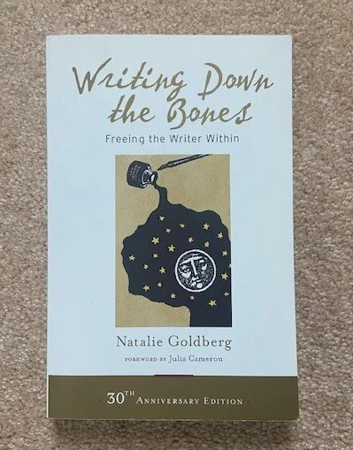 A book titled “Writing Down the Bones: Freeing the Writer Within” by Natalie Goldberg, with a minimalist cover design.