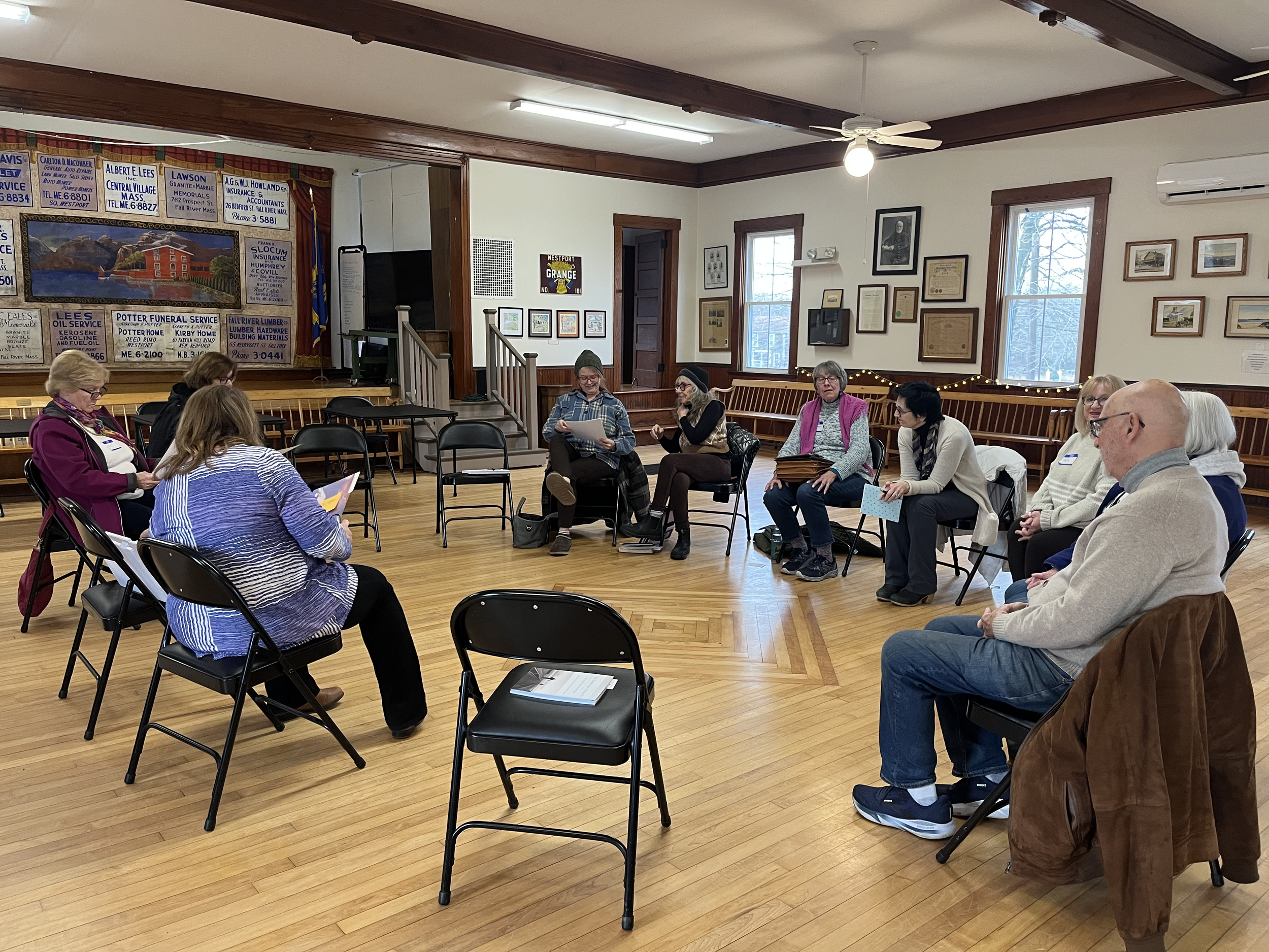 A group of people are seated in a circle engaged in a discussion or workshop