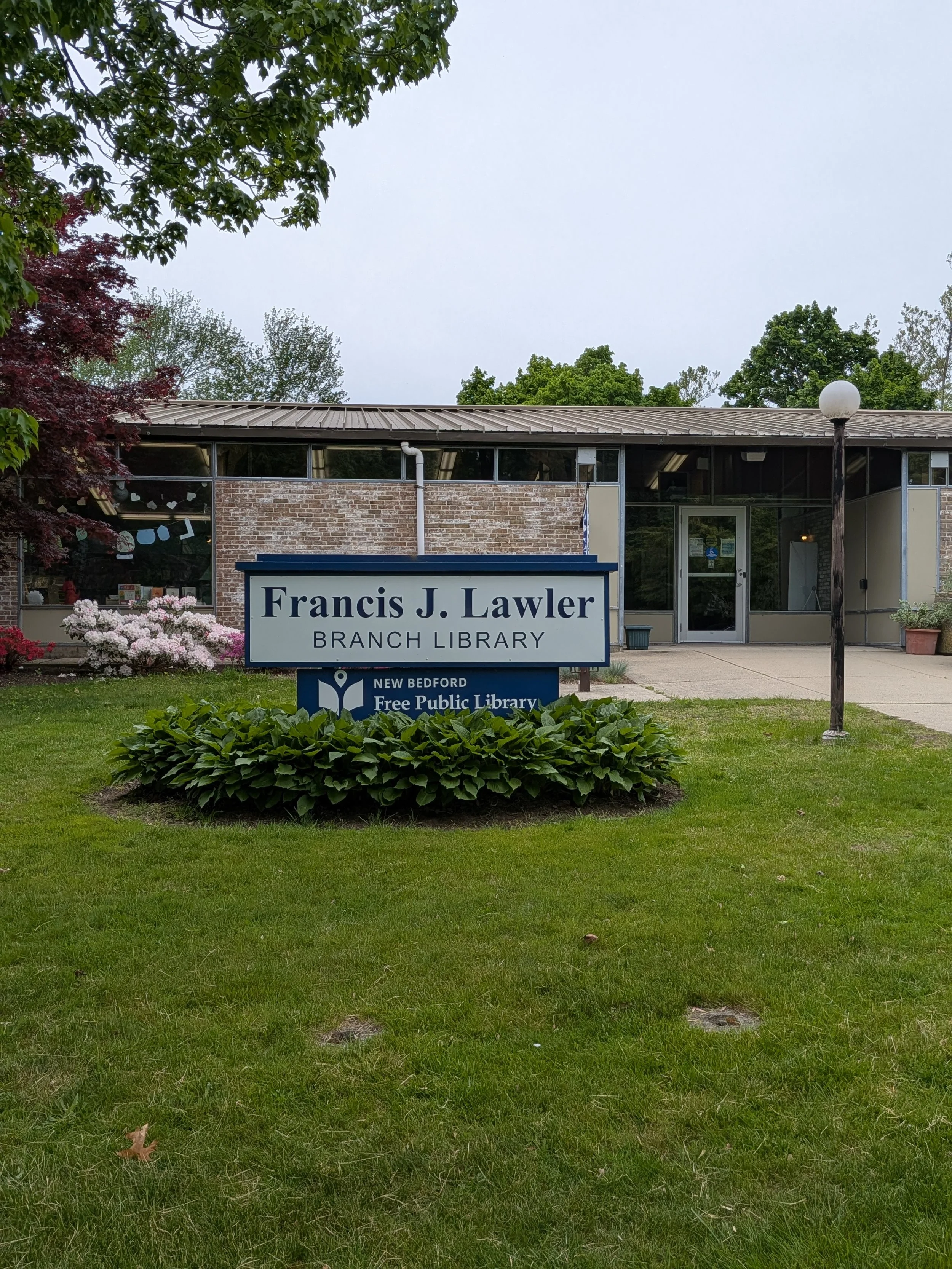 Exterior of the Francis J. Lawler Branch Library with a lawn and library sign in front
