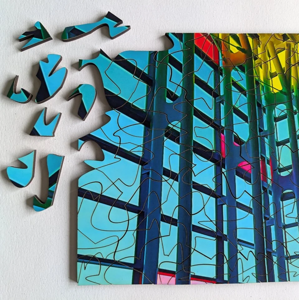 a colorful wooden puzzle, mostly complete with some blue pieces not finished