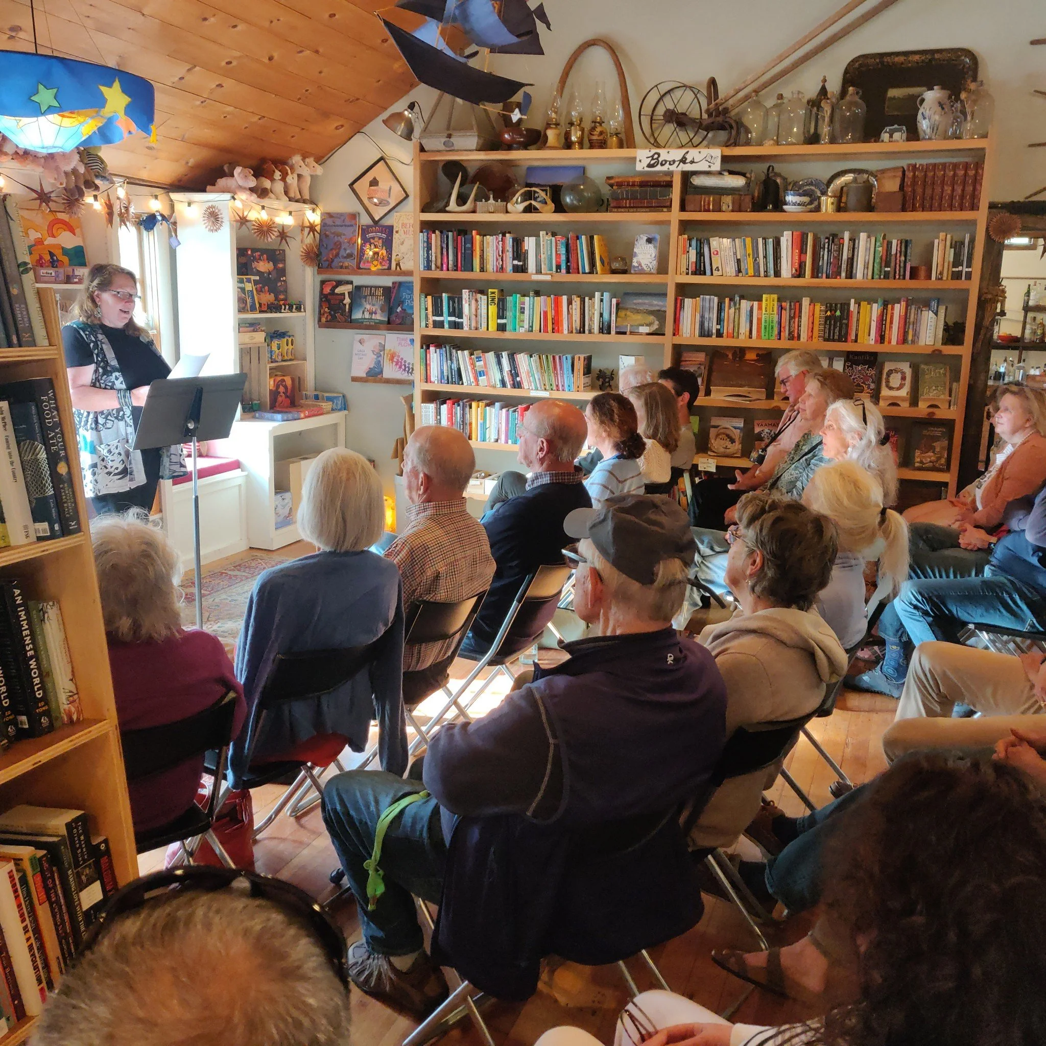 Midori Evans reading at a small community gathering inside Davoll's bookstore.