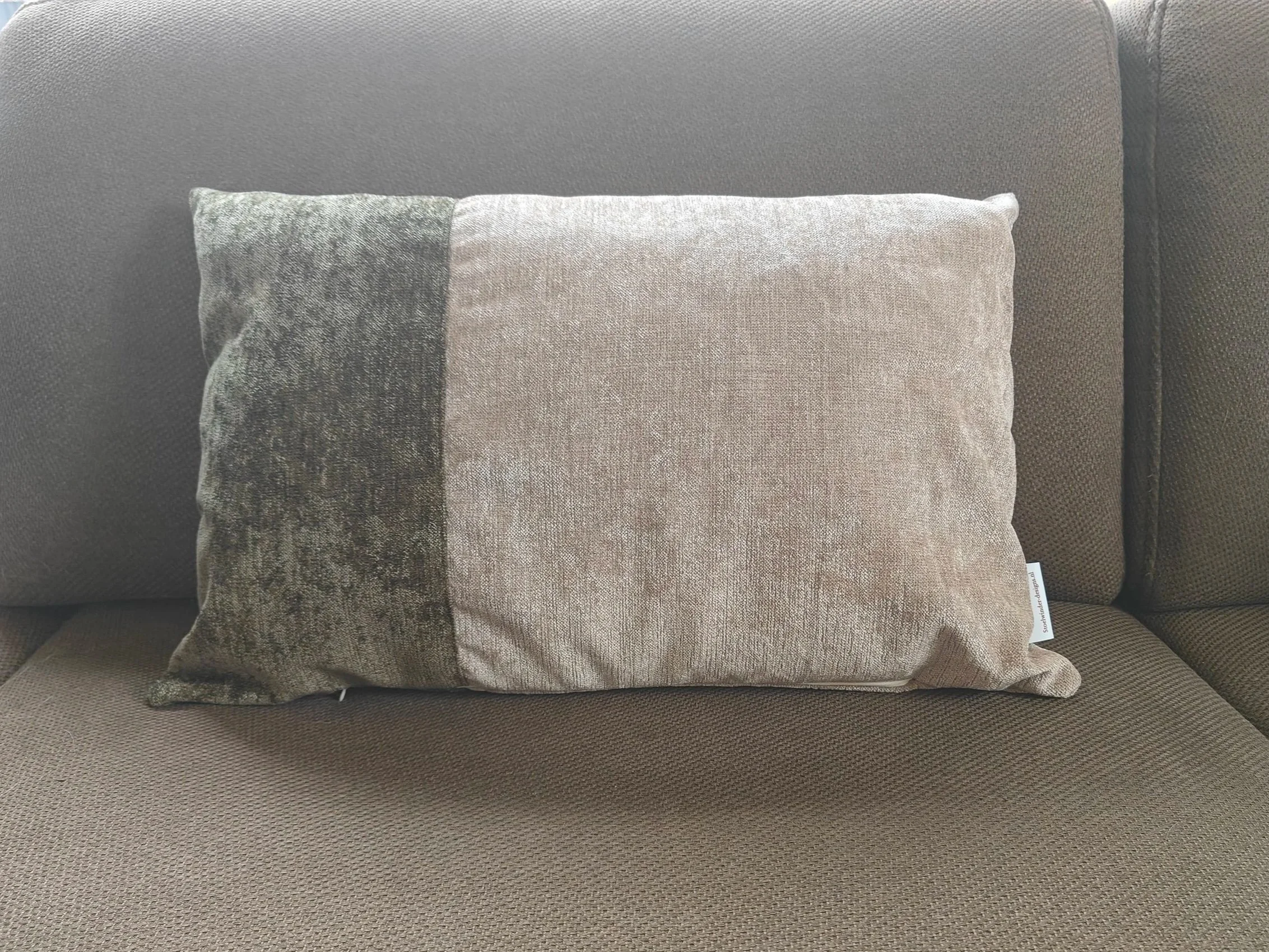 Een houten salontafel met een lade en pootjes in een woonkamer met houten vloer en banken.