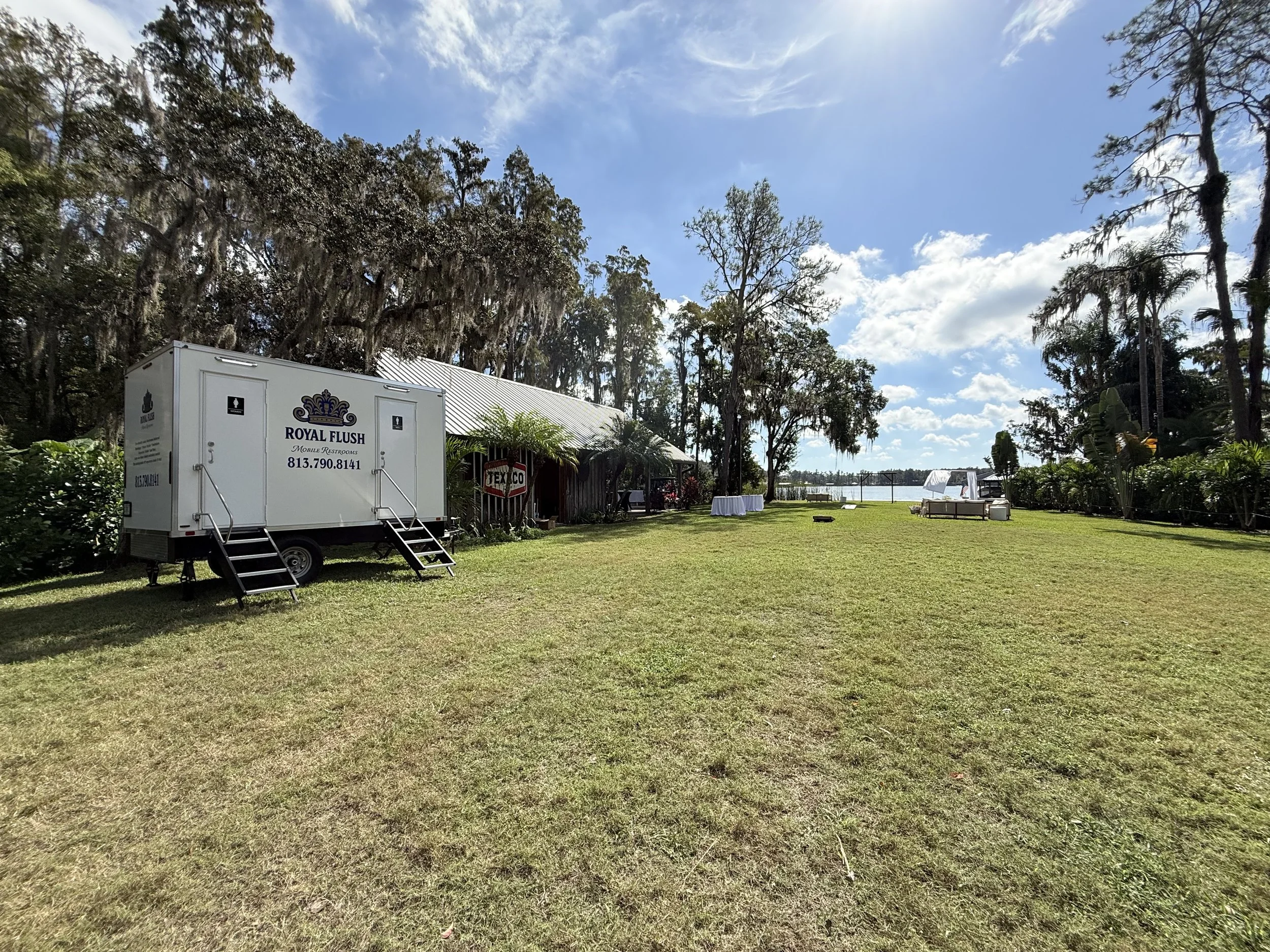 Outdoor wedding venue in Lutz Florida on the lake. 4-station Lang community restroom trailer for up to 250 guests 11.8.2025