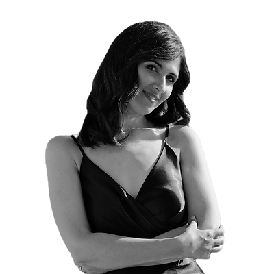 Ragazza sorridente con abito nero e capelli castani mossi in posa