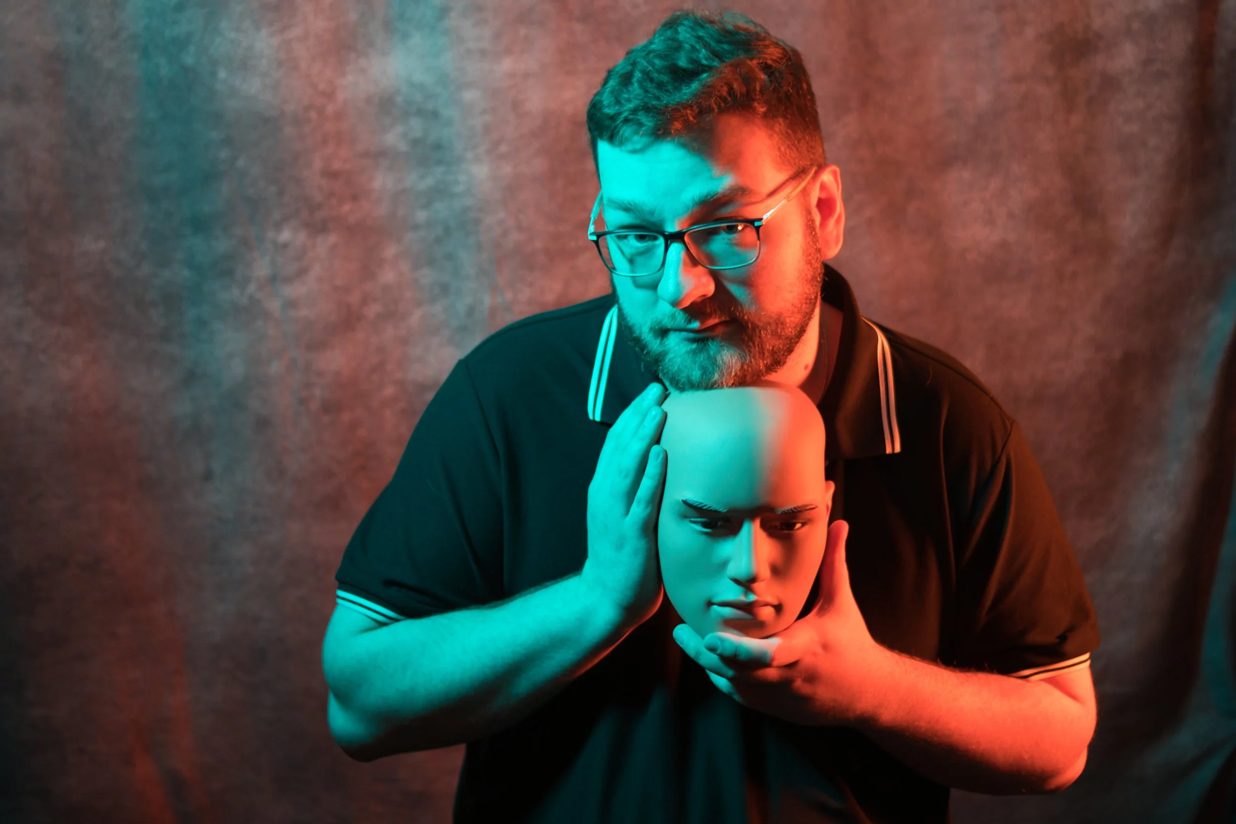A life-sized human skeleton model with a skull, looking to the side, with hand near mouth, against a plain gray background.