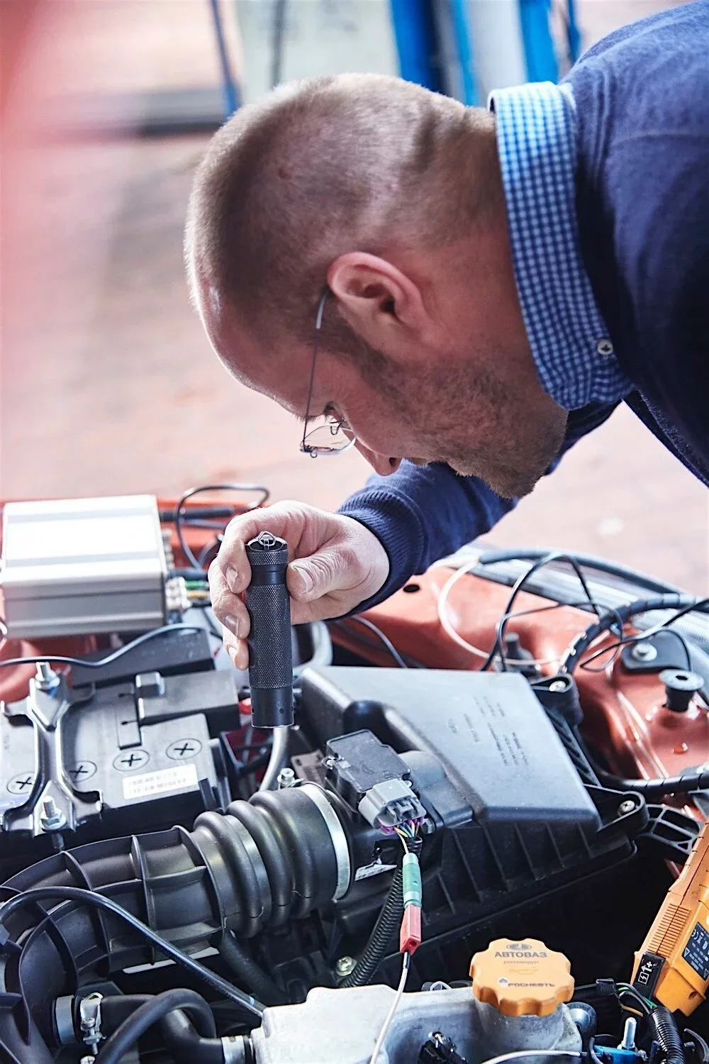 Der Sachverständige Stephan Kober aus Velbert macht eine Motor-Inspektion mit der Taschenlampe.