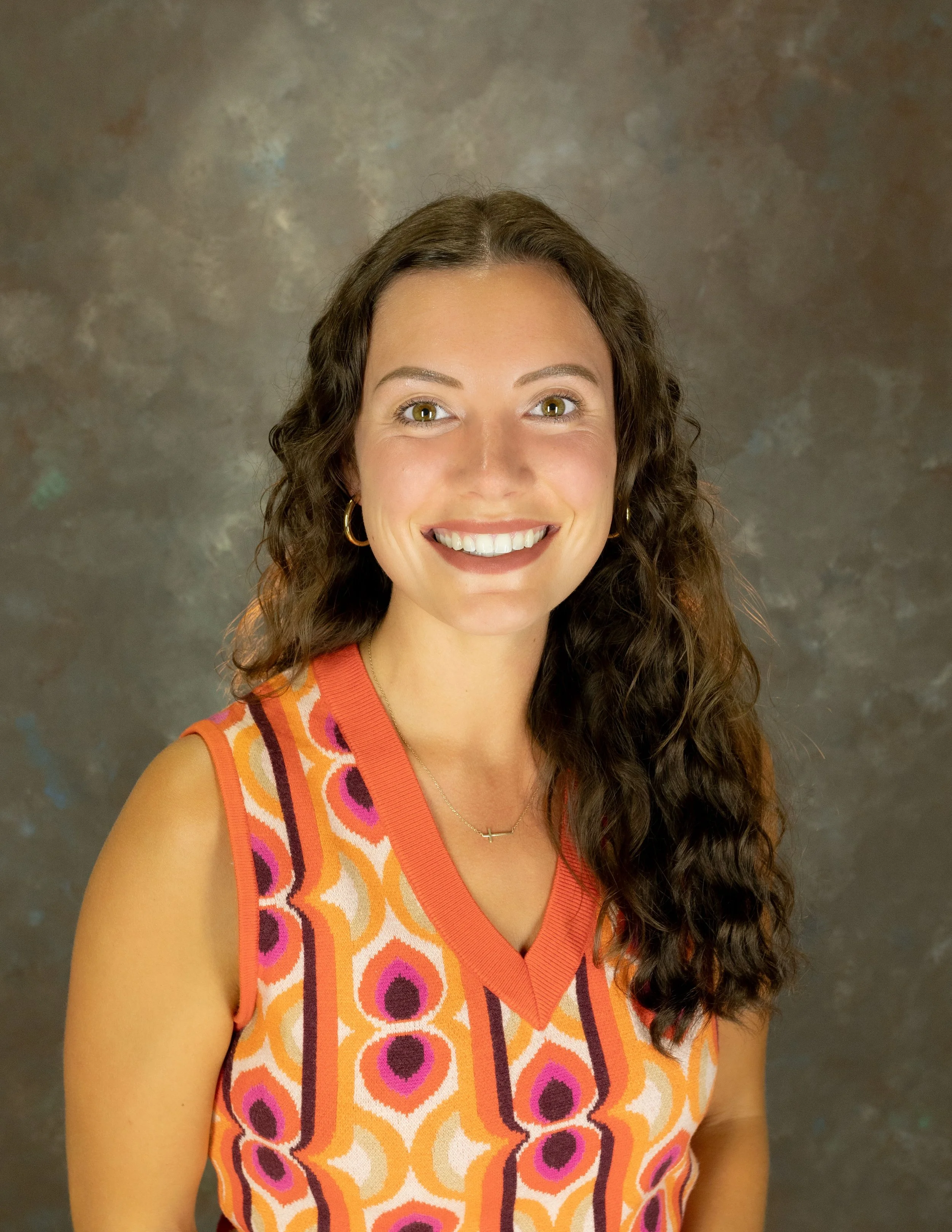 A woman with brown hair smiling.