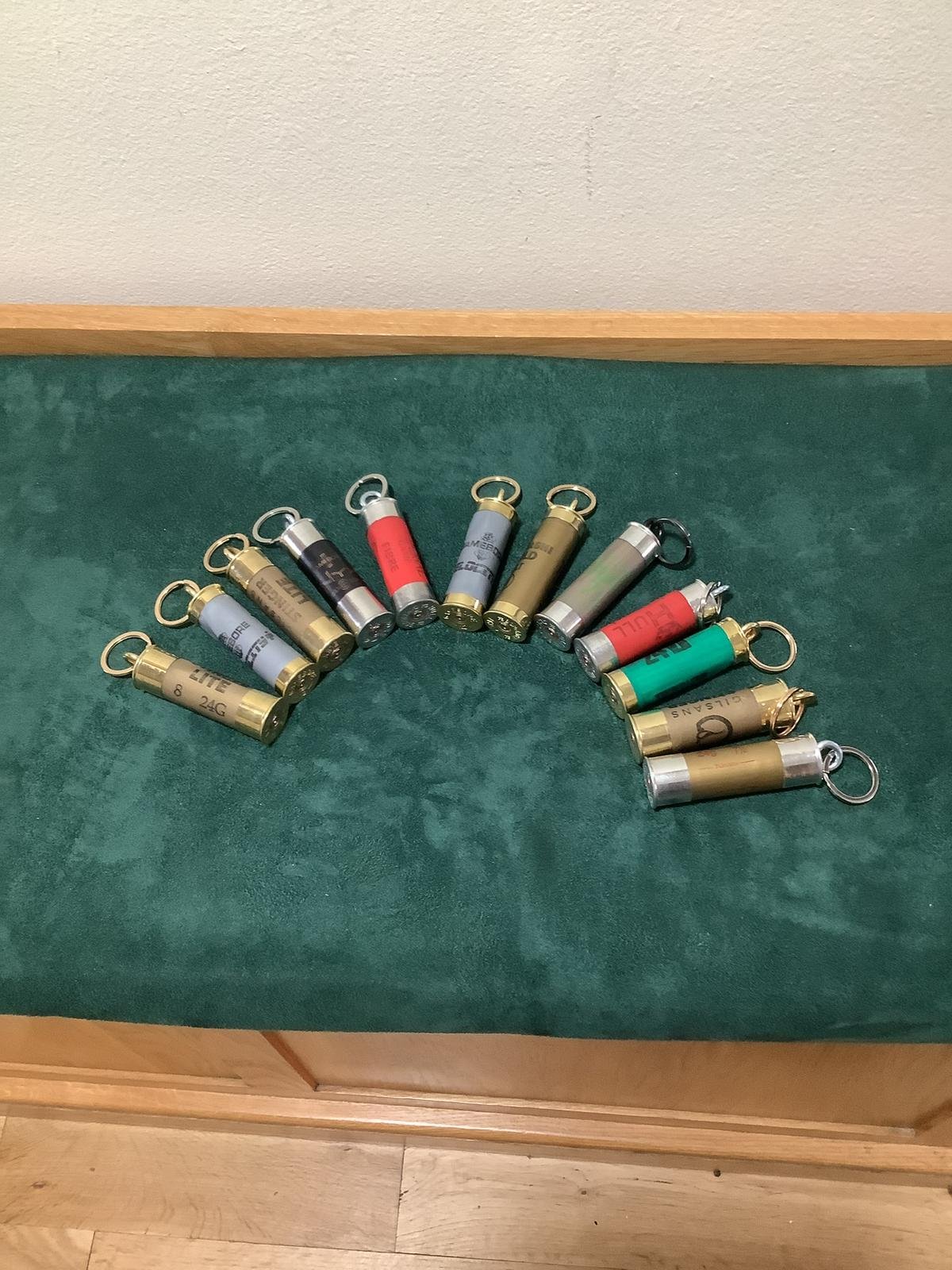 A collection of shotgun shells arranged in a semi-circle on a green surface.