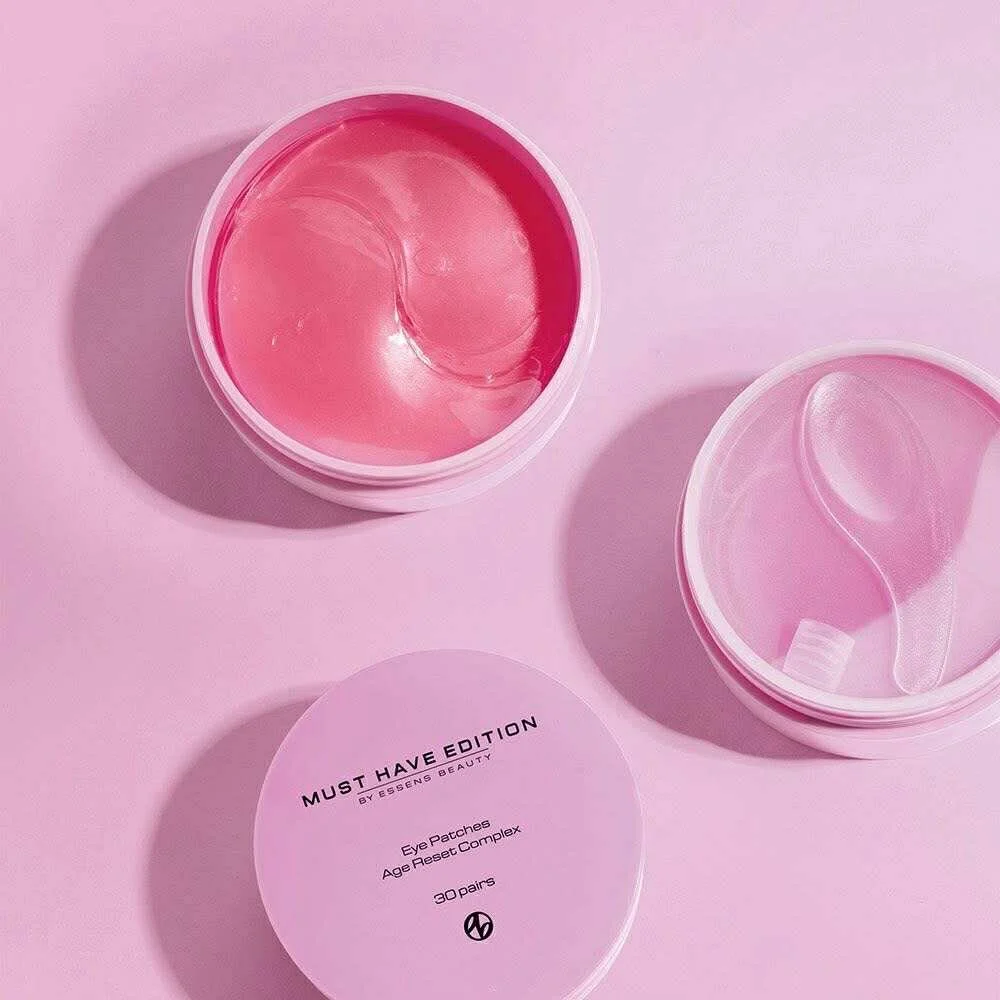 Open pink container with eye patches inside, placed on pink background, with a pink lid labeled 'Must Have Edition' for eye patches.