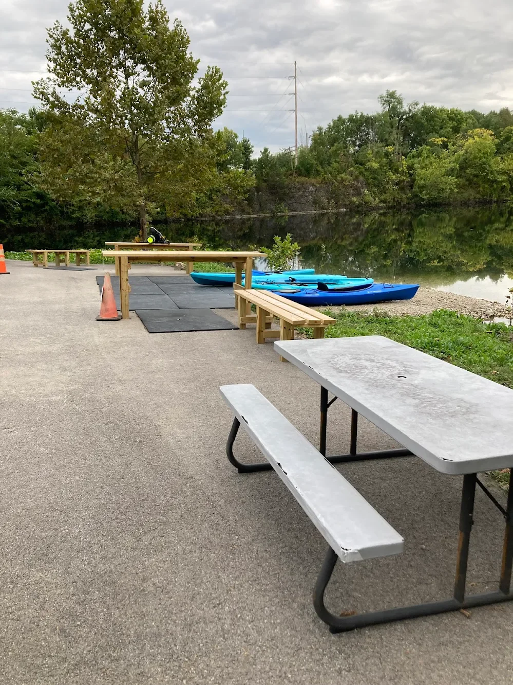 Picnic tables and kayaks along the shoreline at Silver Cup Lake Adventures in Cedarville, Ohio