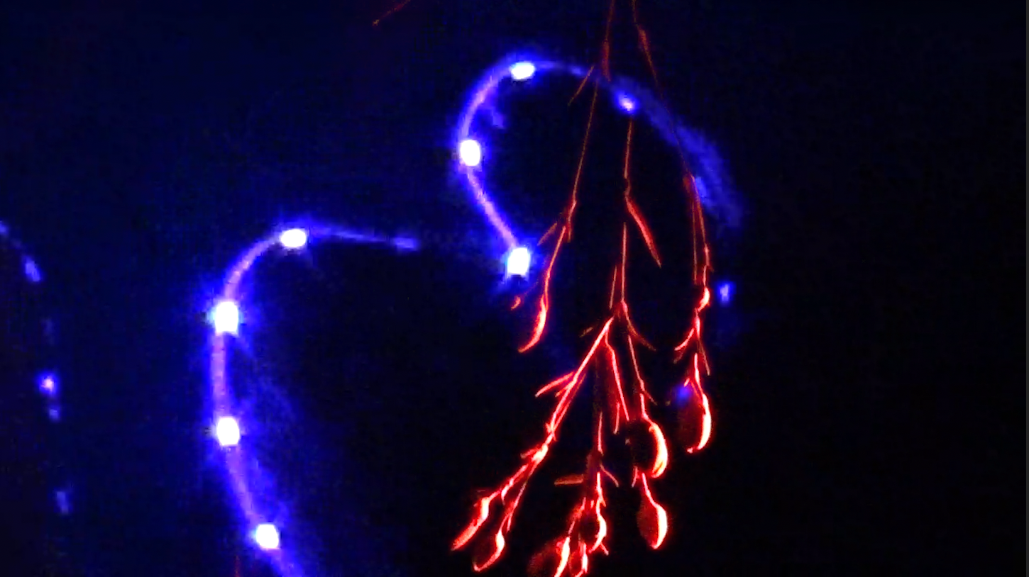 Lightning storm with red and blue lightning strikes against a dark night sky.