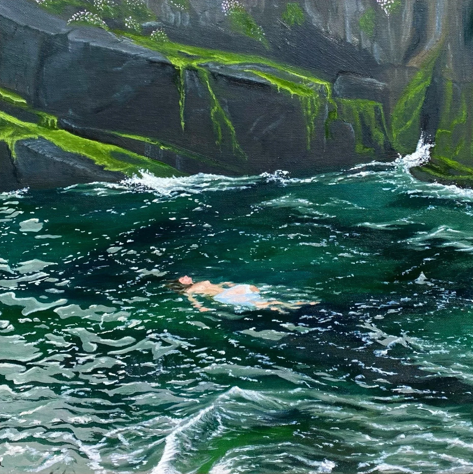 A person swimming in a river with dark green water, surrounded by steep rocks covered in moss.