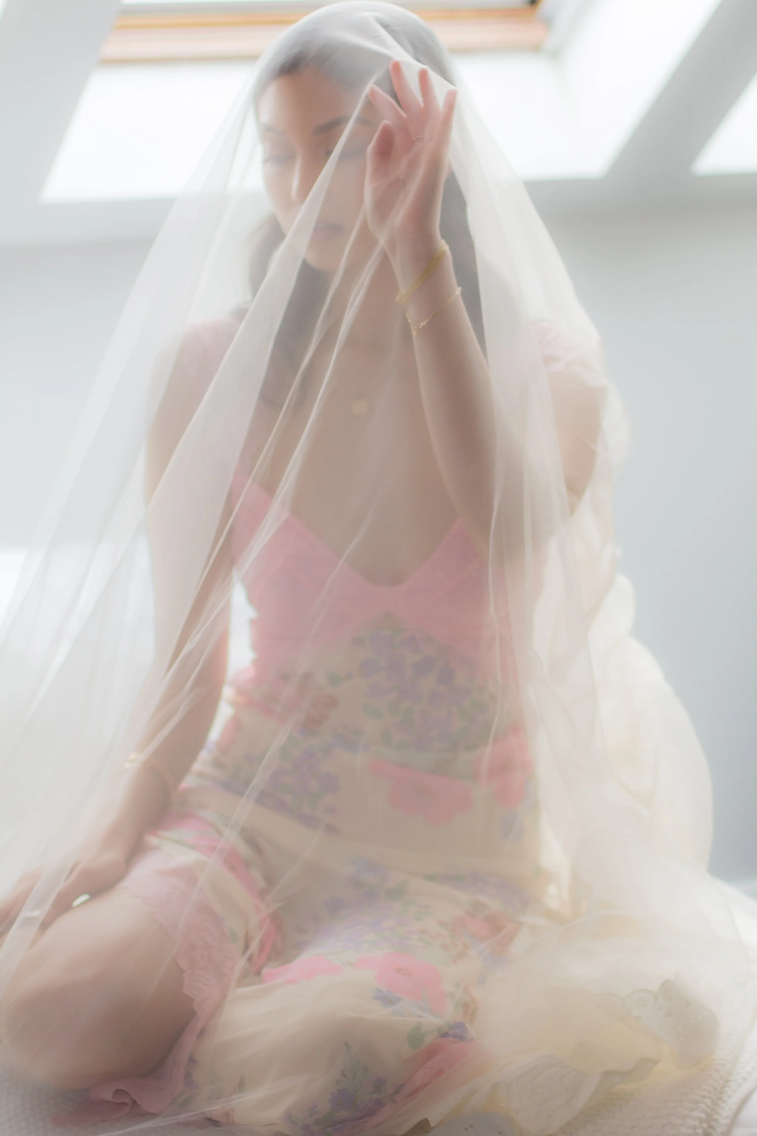 bride posing under bridal veil at boudoir session