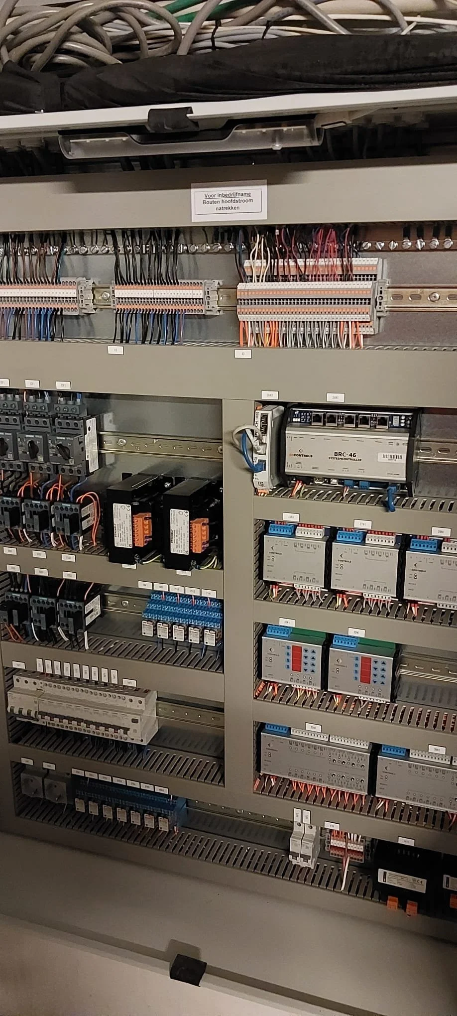 Elektrisch schakelkast met diverse bedrading, relais, en controllers.