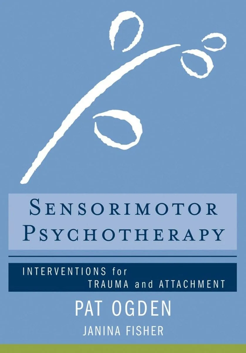 Book cover titled 'Sensorimotor Psychotherapy: Interventions for Trauma and Attachment' by Pat Ogden and Janina Fisher, with a blue background and a white abstract symbol resembling a stylized human figure.