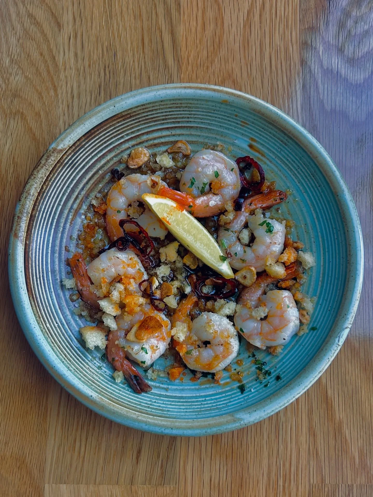 Golden saut&eacute;ed prawns tossed in garlic, extra virgin olive oil, and a gentle kick of chili 🌶️
Finished with crispy crumbs, toasted garlic chips, and a squeeze of fresh lemon for that perfect balance of heat and brightness.

Simple. Bold. Addi